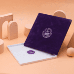 An open, empty square presentation box with a suede cover and foil-blocked pattern commemorating the Platinum Jubilee